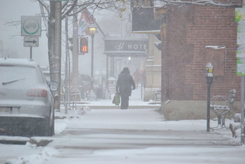 A pedestrian walks in the snow in downtown Charlottetown on Nov. 16, 2018.