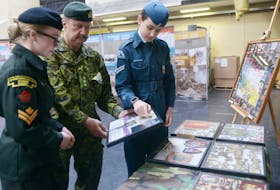Capt. Greg Gallant, curator of the P.E.I. Regiment Museum, Air Cadet Cpl. Harper Hippenstall, left, and Cadet Master Cpl. Sophie Flower, right, look over some of the artifacts included in the “From Vimy to Juno” exhibit on display at the P.E.I. Regiment Museum. The exhibit, created by the Juno Beach Association in partnership with Heritage Canada, is on display in P.E.I. until April 12.