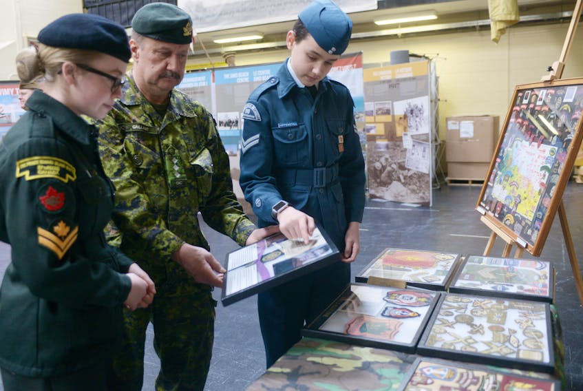 Capt. Greg Gallant, curator of the P.E.I. Regiment Museum, Air Cadet Cpl. Harper Hippenstall, left, and Cadet Master Cpl. Sophie Flower, right, look over some of the artifacts included in the “From Vimy to Juno” exhibit on display at the P.E.I. Regiment Museum. The exhibit, created by the Juno Beach Association in partnership with Heritage Canada, is on display in P.E.I. until April 12.