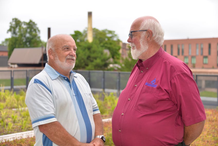 Terry Davis, left, president of Pat and the Elephant, and Halbert Pratt, the non-profit organization’s manager, discuss the new funding agreement at Thursday’s announcement.