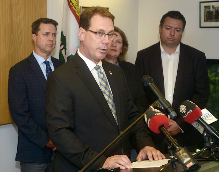 James Aylward announces his resignation as the Leader of the PC Party of Prince Edward Island while surrounded by caucus members on Monday.
