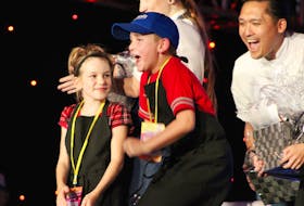 Emery Wood jumps with excitement the moment his name is announced as the winner of the first Junior Chef Challenge at the P.E.I. International Shellfish Festival. Looking on with excitement behind him is his sous-chef Mark Singson, who was the runner-up in season six of Top Chef Canada. On the left is fellow competitor Annabella Sly.