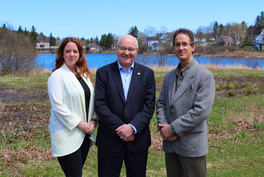 Malpeque MP Wayne Easter, centre, stands near a waterway behind the Hunter River Community Centre on Friday to announce funding for the P.E.I. Watershed Alliance Inc. Easter is joined by the alliance’s project manager Angela Douglas, left, and its president Mike Durant.