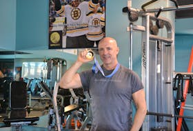 Dave (Eli) MacEachern shows off the gold medal he won at the 1998 Nagano Olympics for the two-man bobsleigh event at Dynamic Fitness in Charlottetown on Feb. 17.