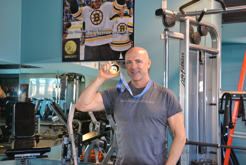 Dave (Eli) MacEachern shows off the gold medal he won at the 1998 Nagano Olympics for the two-man bobsleigh event at Dynamic Fitness in Charlottetown on Feb. 17.