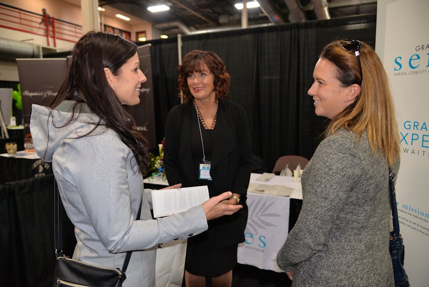 Kerry Smith, left, and her friend Carolyn Mills, right, both of Cooke Insurance, discuss spa options with Virginia MacIsaac, general manager of Grand Senses Spa during the Biz2Biz Expo in Charlottetown on Oct. 18, 2018.