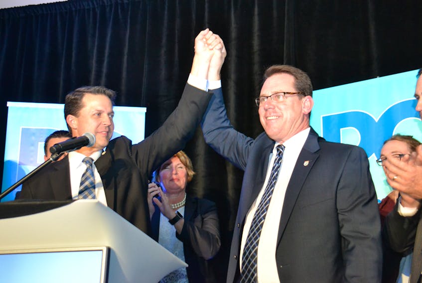 Brad Trivers, left, raised James Aylward's arm in victory Friday night at the PC party leadership convention in Brudenell. Aylward won the leadership vote over Trivers with 1,685 votes to Trivers' 1,107. TERESA WRIGHT/THE GUARDIAN