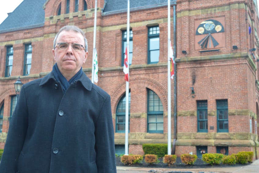 Charlottetown Mayor Philip Brown stands outside City Hall on Monday where the flags have been lowered to half-mast in honour of Green party candidate Josh Underhay and his young son, Oliver, who died on Friday, April 19 when their canoe capsized on the Hillsborough River.