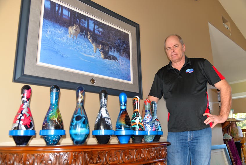 Allan Clark, president of the P.E.I. 5 Pin Bowlers’ Association, displays bowling pins painted by local tattoo artists that will be auctioned off to raise money for the Special Olympics.