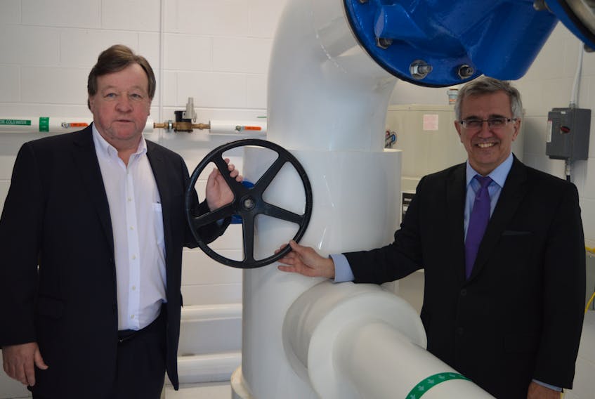 Charlottetown Mayor Clifford Lee, left, and Communities, Land and Environment Minister Richard Brown open the valve to allow water to flow through the pipe at the city’s new wellfield which began producing water on Monday.