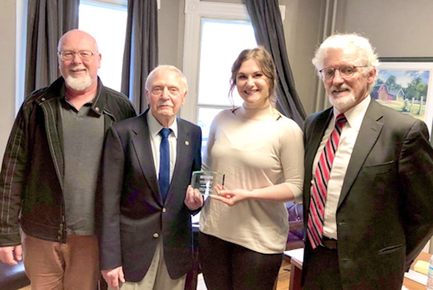 Jennifer Dewland, a graduating student from Holland College’s wildlife conservation technology program, receives the inaugural Davida Stewart Memorial Award from Russell Stewart, husband of the late Davida Stewart. Also on hand for the presentation is their son, David, left, and Holland College president Sandy MacDonald.