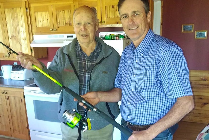 Gordon Murray accepts a new fishing rod, delivered by Borden-Kinkora MLA Jamie Fox. An anonymous woman offered to buy Murray a new rod on Facebook after his was confiscated by a conservation officer on Tuesday. Murray is visiting from Kitchener, Ont.