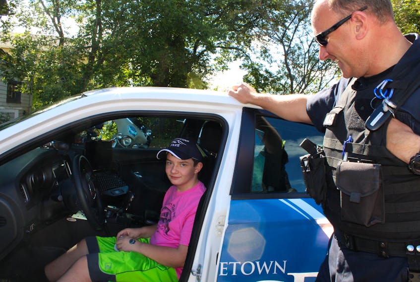 Twelve-year-old Kayson checks out the police cruiser with Const. J.D. Gallant, who also attended the anti-bullying event on Saturday.