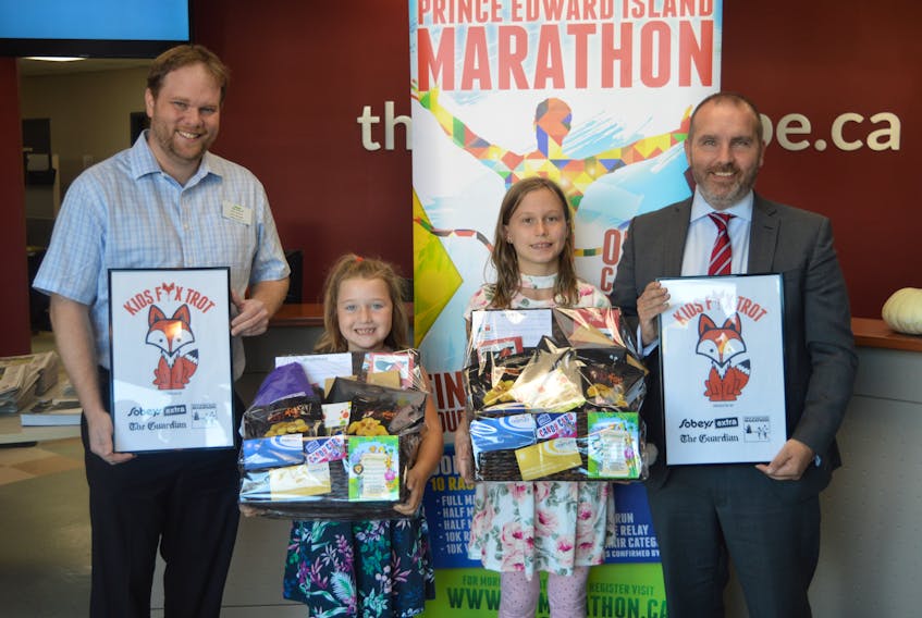 Eva Lyn Connor, 6, second from left, and Ella Hanus, 10, are the two winners of a contest conducted by the P.E.I. Marathon and The Guardian to name a new kids event and give it a logo. It will now be called the Kids Fox Trot. Helping to promote the event are Matt Gauthier, left, Sobeys Extra store manager, and Colin Sly, regional sales manager of The Guardian and the Journal Pioneer.