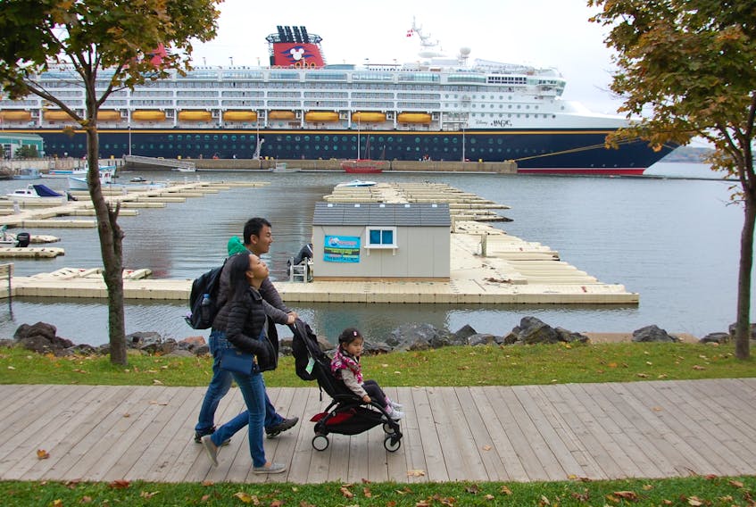 A family walk along the Charlottetown boardwalk to enjoy a stop in the city. The family are among the 2,400 passengers aboard the Disney Magic - the first ship from the Disney Cruise Line to ever visit the capital city. (JIM DAY/THE GUARDIAN)
