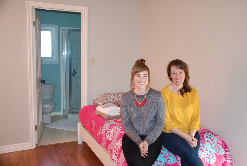 Blooming House co-founders Liz Corney, left, and Brynn Devine sit on a bed in one of the bedrooms in the new shelter for women that opened Friday, Jan. 25, 2019.