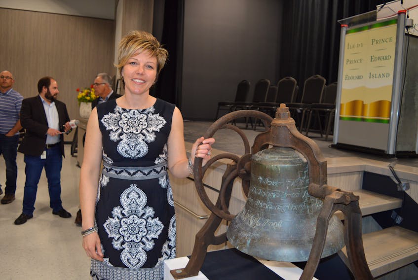 Marise Chapman, principal at École La-Belle-Cloche, stands beside the venerable bell of Rollo Bay on display in the new French school, during the school’s official opening on Friday.