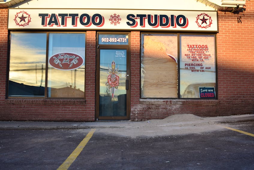A broken window and the storefront of Extreme Ink on Kensington Road are boarded up Monday morning following a violent early morning altercation on Sunday.