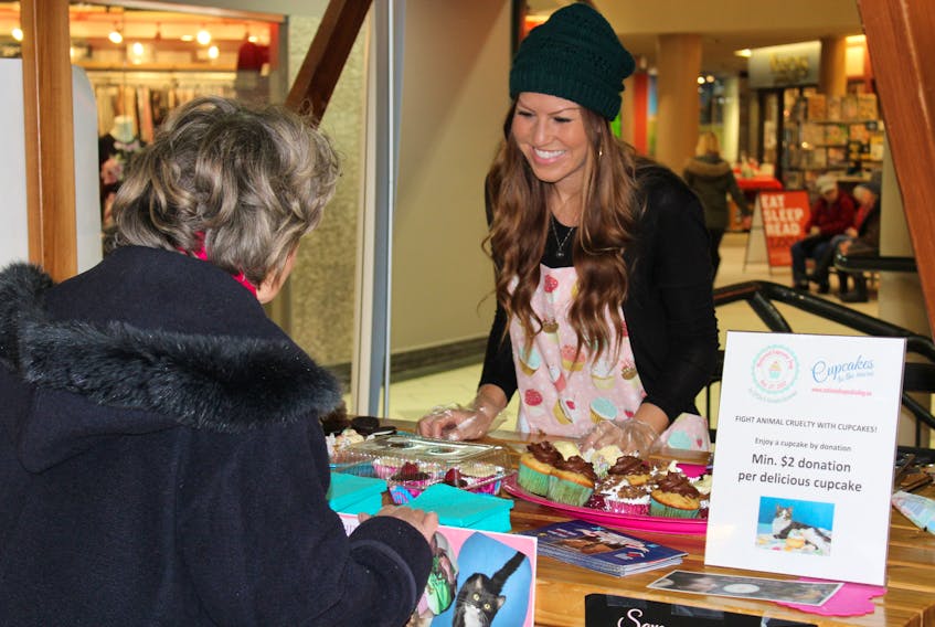 Emma Turner’s grandmother visits her cupcake booth at the Confederation Court Mall on National Cupcake Day Monday. The national promotions raises funds for animal shelters across Canada through cupcakes baked and sold by local supporters.