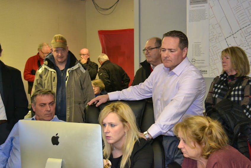 Liberal candidate Bob Doiron, right, is surrounded by supporters at his campaign headquarters Monday evening as they watch results come in from the District 11 byelection. Doiron finished second to Green party candidate Hannah Bell. (Teresa Wright/The Guardian)
