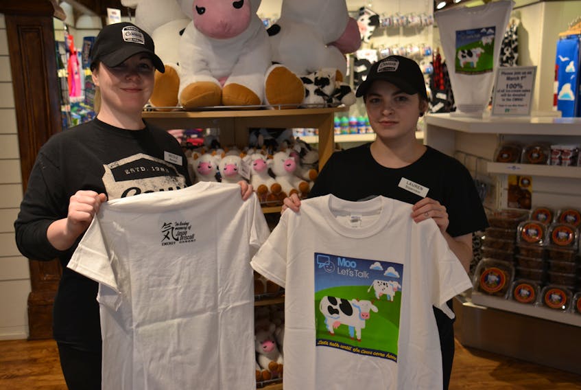 Nicole Lewis and Lauren Bridges, employees at Cows on Queen Street in Charlottetown, show off the limited edition T-shirt designed to raise funds for the Canadian Mental Health Association, P.E.I. division, in honour of Jason Driscoll, an Island man who lost his battle with mental health last spring.