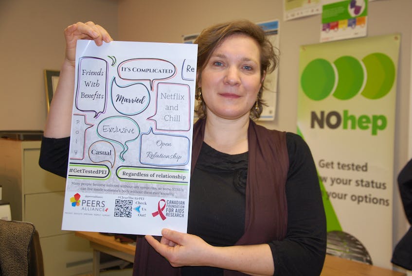 Cybelle Rieber, executive director of the PEERS Alliance, holds one of the posters being used in an awareness campaign on sexually transmitted blood-borne infections (STBBI). The posters, designed by Island youth aged 16 to 25, are being placed around Charlottetown in bars, cafes and some health facilities.