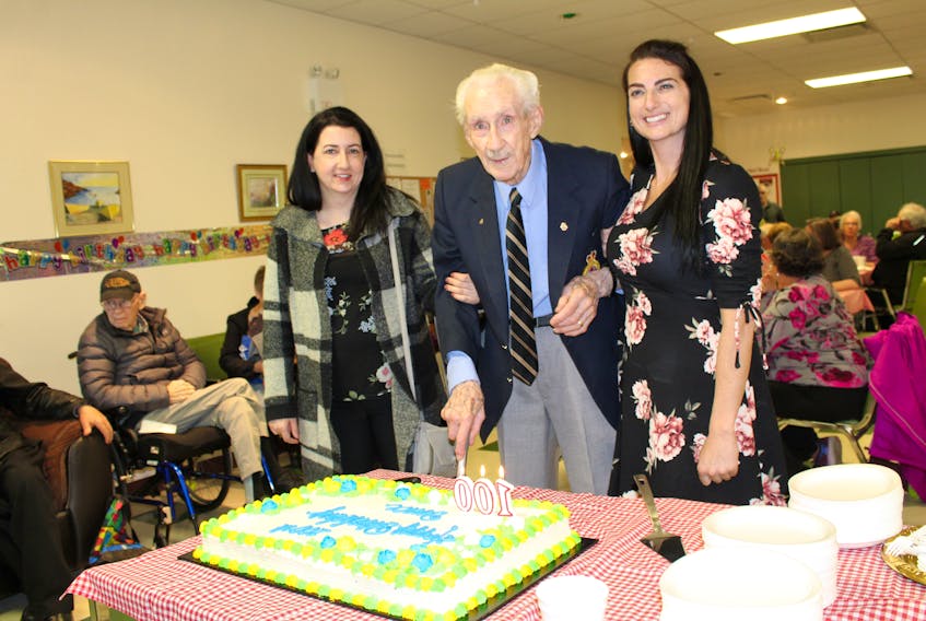 Bruce Coulson and his granddaughters Sarah Coulson-Gillespie, left, and Kirah Coulson-Gillespie moments before he cut into his 100th birthday cake.