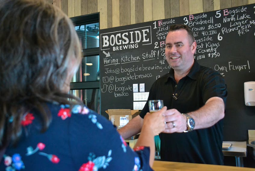 David McGuire serves a customer at Bogside Brewing in Montague.