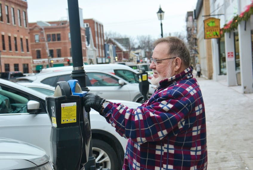 Eugene Himmelmann puts money into one of the metered parking spots in downtown Charlottetown on Friday. He would like to see free parking in the future. Mayor Philip Brown is willing to look at the whole issue of metered parking.