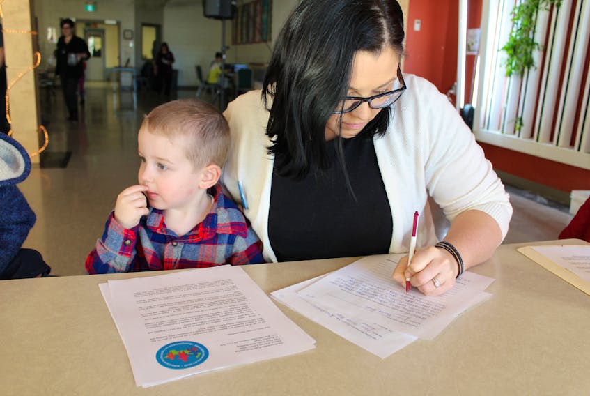 Brooke Hupé of Winsloe and her three-year-old son, Pascal, personalize a letter to Premier Wade MacLauchlan about supporting an increase to professional early learning and child care workforce on P.E.I. during the pancake breakfast and educational rally to improve early childhood educator wages. The event was held Saturday, Jan. 26, 2019, at Carrefour Theatre in Charlottetown.
