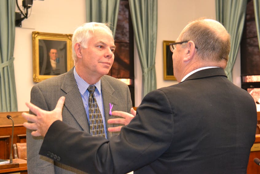 P.E.I. Green leader Peter Bevan-Baker, left, speaks with Finance Minister Allen Roach in the legislature in this file photo.