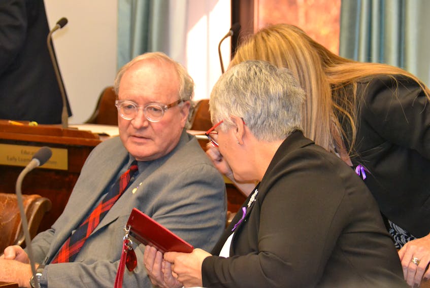 Premier Wade MacLauchlan speaks with Liberal MLAs Tina Mundy and Paula Biggar, right, in the provincial legislature. -File photo