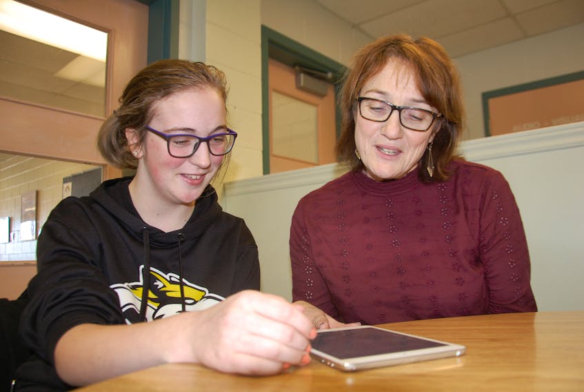 Resource teacher Karen Carmichael, right, provides learning assistance to Queen Charlotte Intermediate School student Katie Beaton. Additional psychologists, intervention teachers and assistive tech facilitators were hired last year under a three-year psychology strategy.