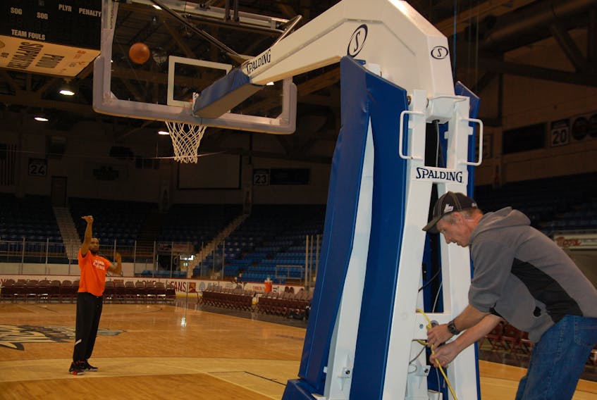 Island Storm player Tirrell Baines warms up for a basketball game at Eastlink Centre in Charlottetown as Brooke Gregory, an employee with the City of Charlottetown, works on the shot clock. Although a new multi-use sports and events centre isn’t on the city’s list of capital projects this year, it doesn’t mean the issue is dead.