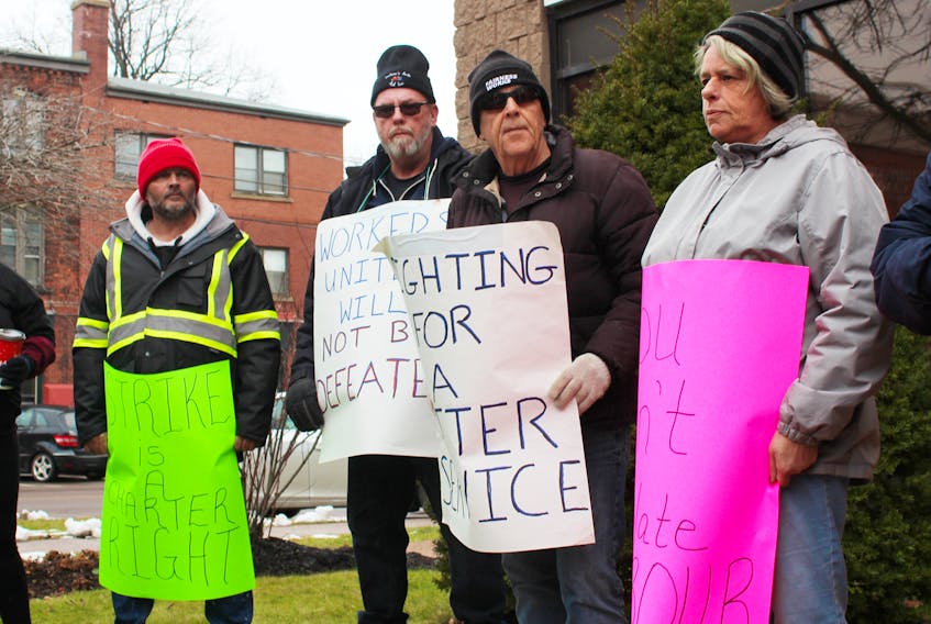 Postal workers and members of other unions stand outside Charlottetown MP Sean Casey’s office on Saturday while rallying against the federal government’s recent back-to-work legislation. About 30 Islanders took part in the protest as part of a national day of action.