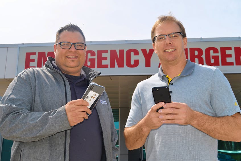 Cory Rusk, left, owner and operator of Device Doctors in Charlottetown, has donated two charging stations for mobile devices that are currently in use at the Queen Elizabeth Hospital’s emergency department waiting room. Mike MacDonald, nurse manager of the ER, said being able to keep a device charged might take some of the burden off the long waits.