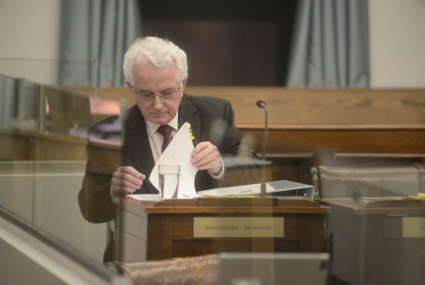 Independent MLA Bush Dumville sorts through some papers before a recent question period at the legislative assembly.