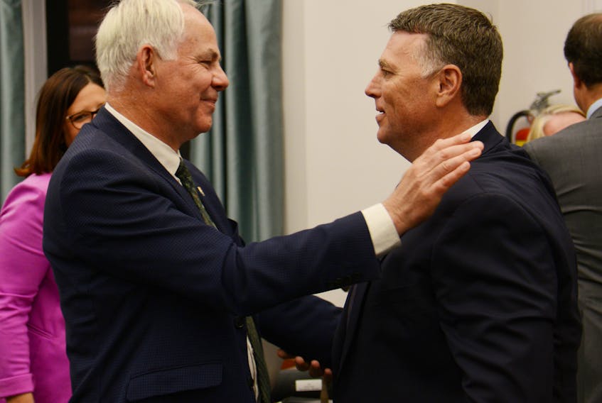 Opposition Leader Peter Bevan-Baker, left, and Premier Dennis King share a hug before the opening of question period Tuesday. It was the first question period under the newly-elected PC government.