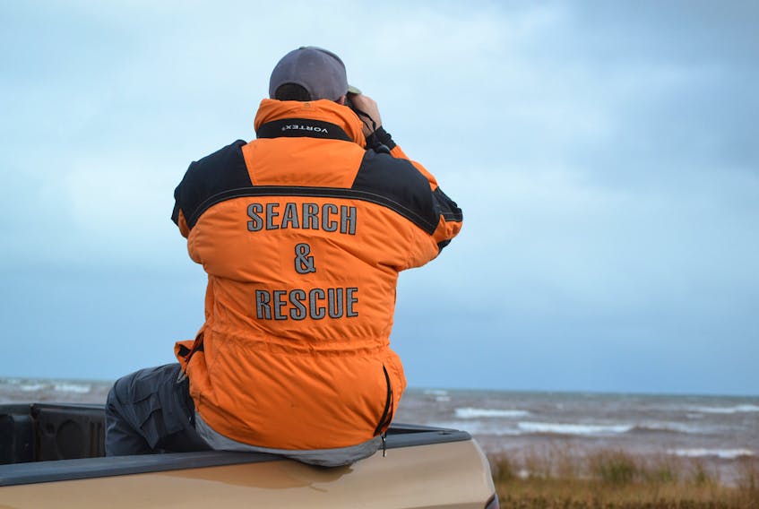 A search and rescue member scans the horizon Wednesday for any sign of the two West Prince fishermen who are missing after their vessel capsized in the Gulf of St. Lawrence Tuesday.