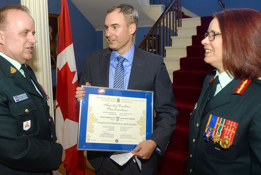 Lt.-Col. Steve Wynne, left, and Brig.-Gen. Josee Robidoux, right, congratulate Charlottetown Rural principal Dylan Mullally following the Canadian Forces Liaison Council (CFLC) awards ceremony held at Government House on Wednesday. The high school, which is where Wynne is also a vice-principal, was one of several P.E.I. organizations recognized for their commitment to Canada’s Reserve Force.