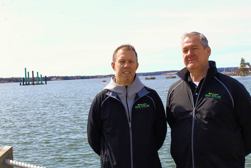 Ride Solar co-founders Steve Arnold (left) and Peter Ixkes stand by the Marina, where their solar-powered boat will set sail this July. The Isola Solaretto will serve as a dinner cruise and tour boat.