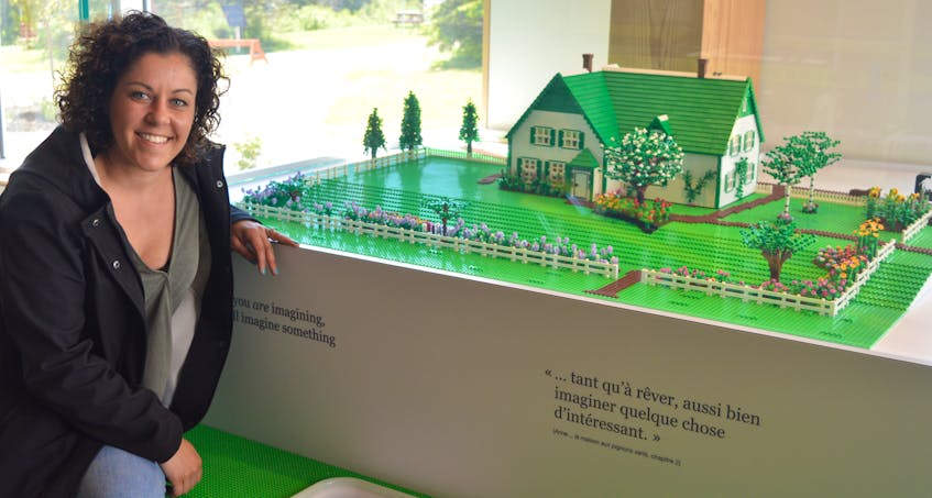 Sara Mikail, project manager with KubikMaltbie, a sub-contractor that worked on fabrication and installation of the new L.M. Montgomery exhibit in Cavendish, sits next to a model of the Green Gables house and property made entirely of Lego pieces. It took Island artist Ben MacLeod 100 hours to complete it.