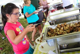 Eight-year-old Julia Hurry, of Charlottetown, scoops up some potatoes for a hearty breakfast during the Breakfast on the Farm in Rustico Saturday.