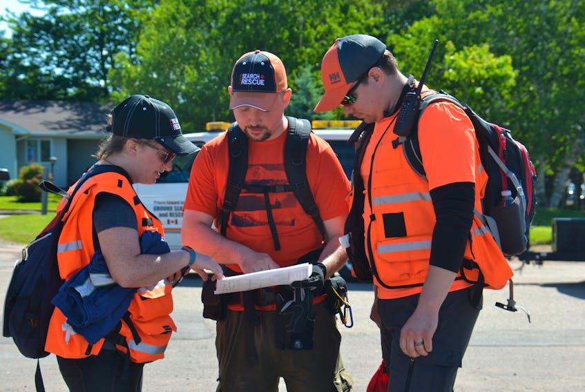 Volunteers with P.E.I. Ground Search and Rescue go over their instructions for a mock search and rescue held in Montague and Brudenell on Sunday.