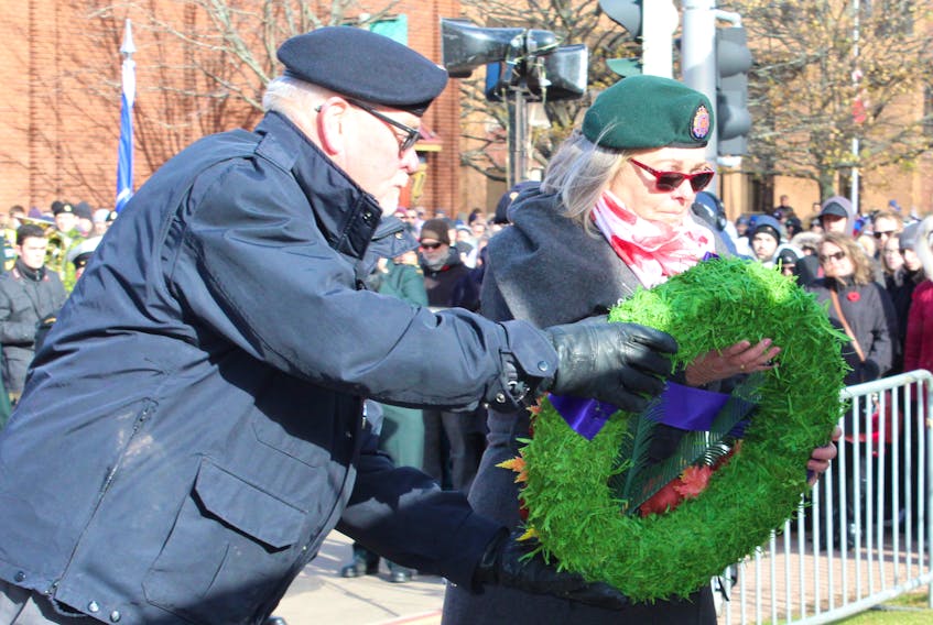 Comrade Jack MacIsaac escorts Silver Cross mother Diana MacDougall, who was the first person to lay a wreath at the cenotaph in Charlottetown for the Remembrance Day ceremony in P.E.I.'s capital city Sunday.