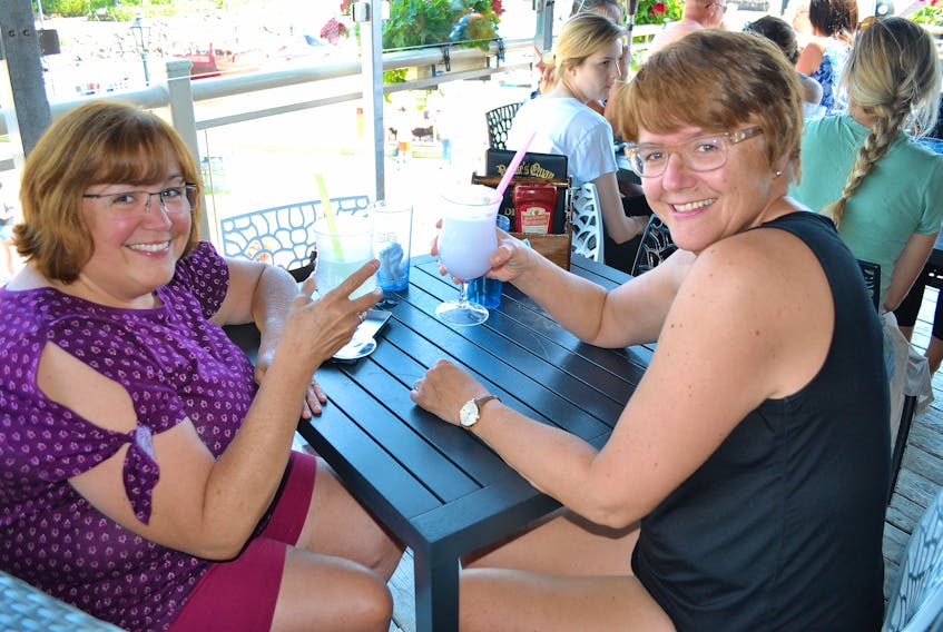Lynn Gallant, Rustico, and Marcia Berthier, St. Albert, Alta. cool off earlier this summer on the deck at Peake's Quay in Charlottetown. With warm weather in the forecast, Islanders and visitors will be heading to decks and patios to enjoy the great outdoors before fall officially arrives next week. The forecast high for today is 24 C, with the temperatures heading for 25 C on Saturday. The sunny sky will be replaced by a mix of sun and cloud on Sunday, but the temperature is forecast to make it to 22 C.