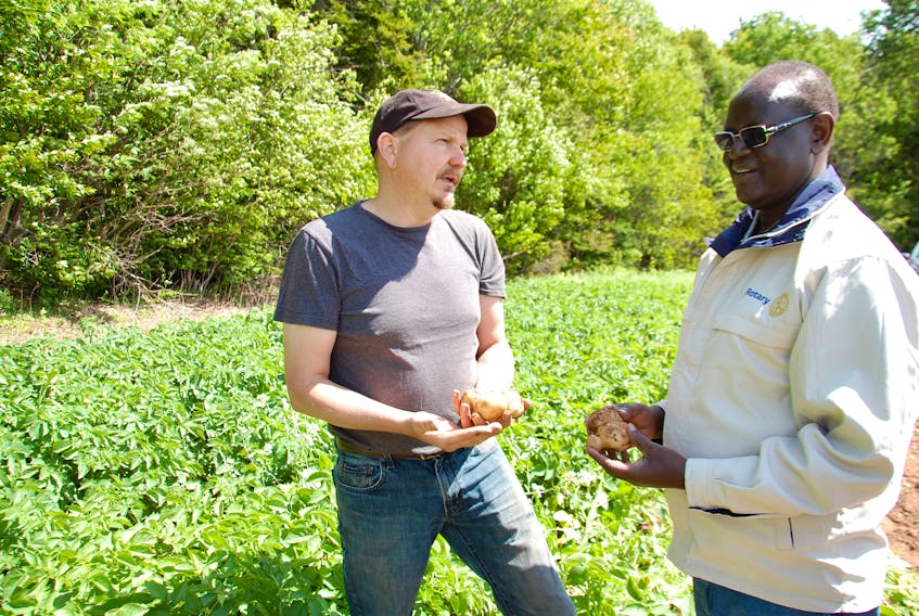 Kiraitu Murungi, governor of Meru County in Kenya, chats Thursday with Randy Visser of Gerrit Visser & Sons in a potato field in Roseberry. Murungi is part of a delegation from Kenya exploring potato growing in P.E.I.