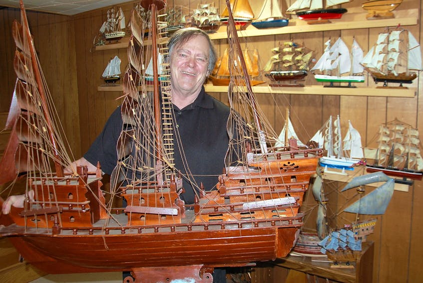 Chris Annett of Charlottetown looks admiringly at a large model boat placed prominently on the mantel of his fire place. Annett has purchased approximately 400 model boats that are displayed throughout his house on window sills, coffee tables and cupboard tops.