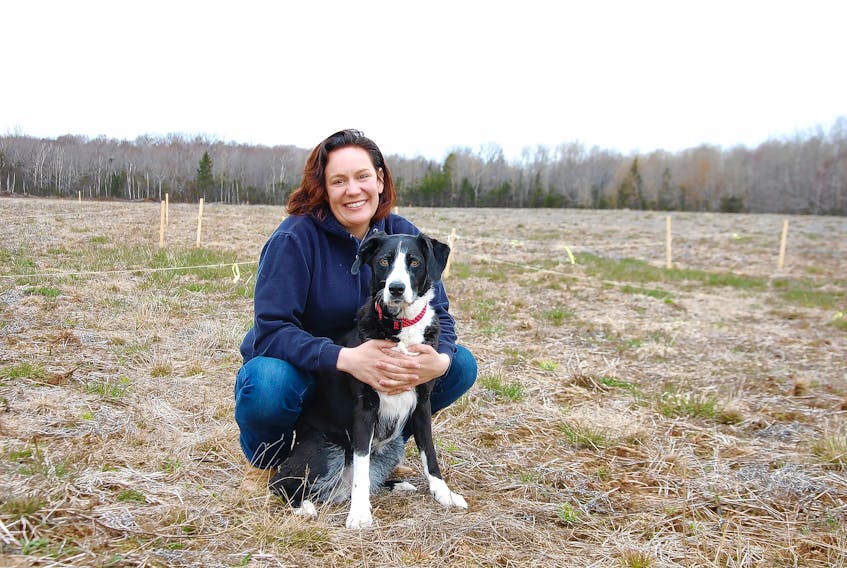 Ellen Jones and her dog, Lalla, pose on the 7.5-acre property Jones has purchased to restart her horse therapy operation that has been idle for almost two years since the province expropriated her property in Cornwall.