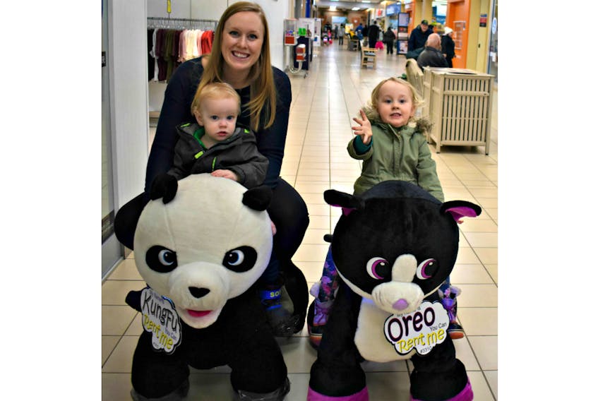 Lindsay Ramsay with her son Thomas and daughter Nora enjoy cruising through the County Fair Mall on Stuffy Riders, a new attraction at the Summerside centre.